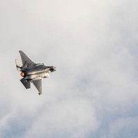 アフターバーナーを噴射して雲の中を飛行する戦闘機の写真