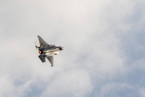 アフターバーナーを噴射して雲の中を飛行する戦闘機