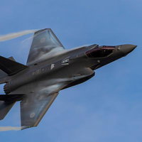 青空の中を飛行する航空自衛隊のF-35ライトニング戦闘機の写真