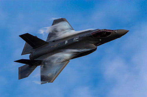 青空を背景に高速飛行するステルス戦闘機