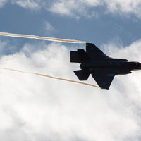 白い雲が浮かぶ空を飛行する航空自衛隊の戦闘機の写真