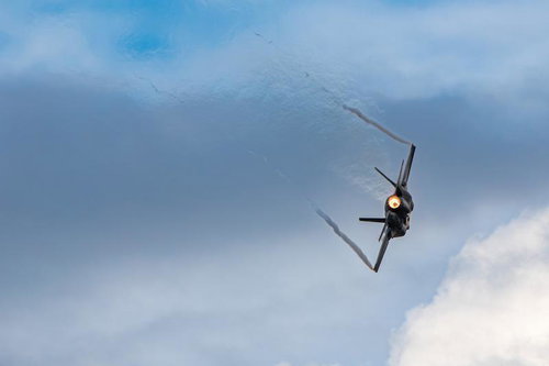 曇り空を背景に飛行する航空自衛隊の戦闘機