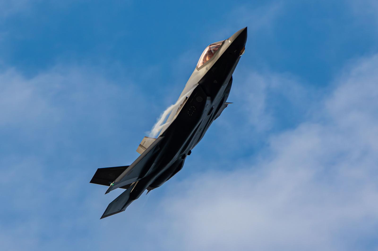 Gray fighter jets of the Japan Air Self-Defense Force ascending against a background of blue sky and clouds