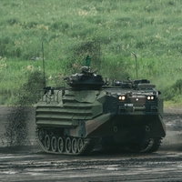 泥を巻き上げ進む 新装備の水陸両用車（AAV）の写真