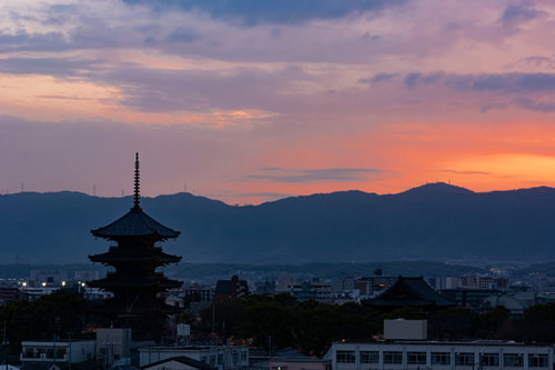 薄く紅が残る空の下ライトアップの始まった東寺