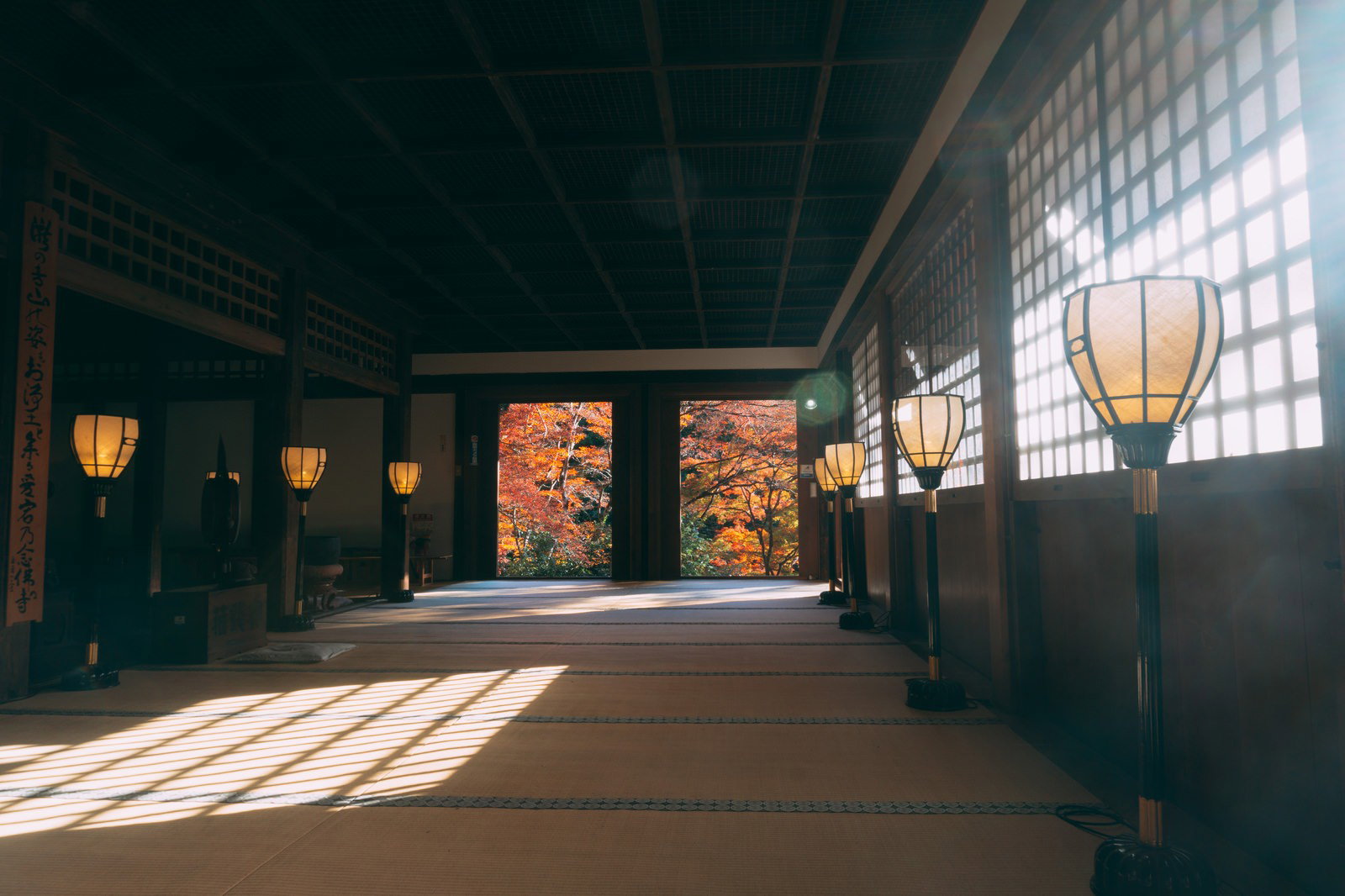 障子越しに光が差し込む本堂内部と紅葉の秋景色