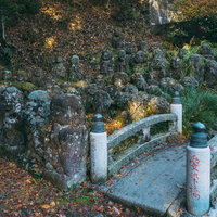 多宝塔横に立ち並ぶ羅漢像と小さな石橋の写真