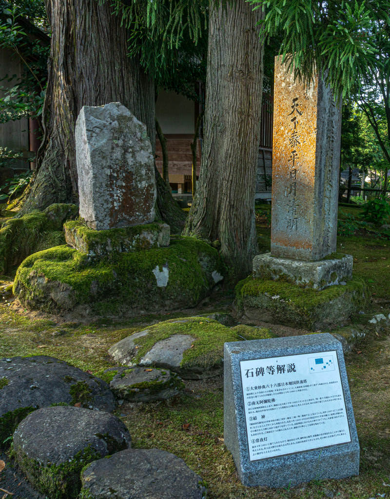 寺社境内に並ぶ古い石碑と解説板