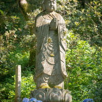 足元に紫陽花の鉢植えが飾られた長谷寺の石仏の写真
