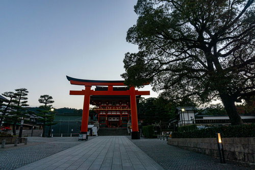 石畳の先、背後からの薄っすらとした朝の気配の中に建つ二番鳥居とその先に見える楼門