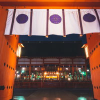 朱色の楼門越しに見える外拝殿の夜景の写真