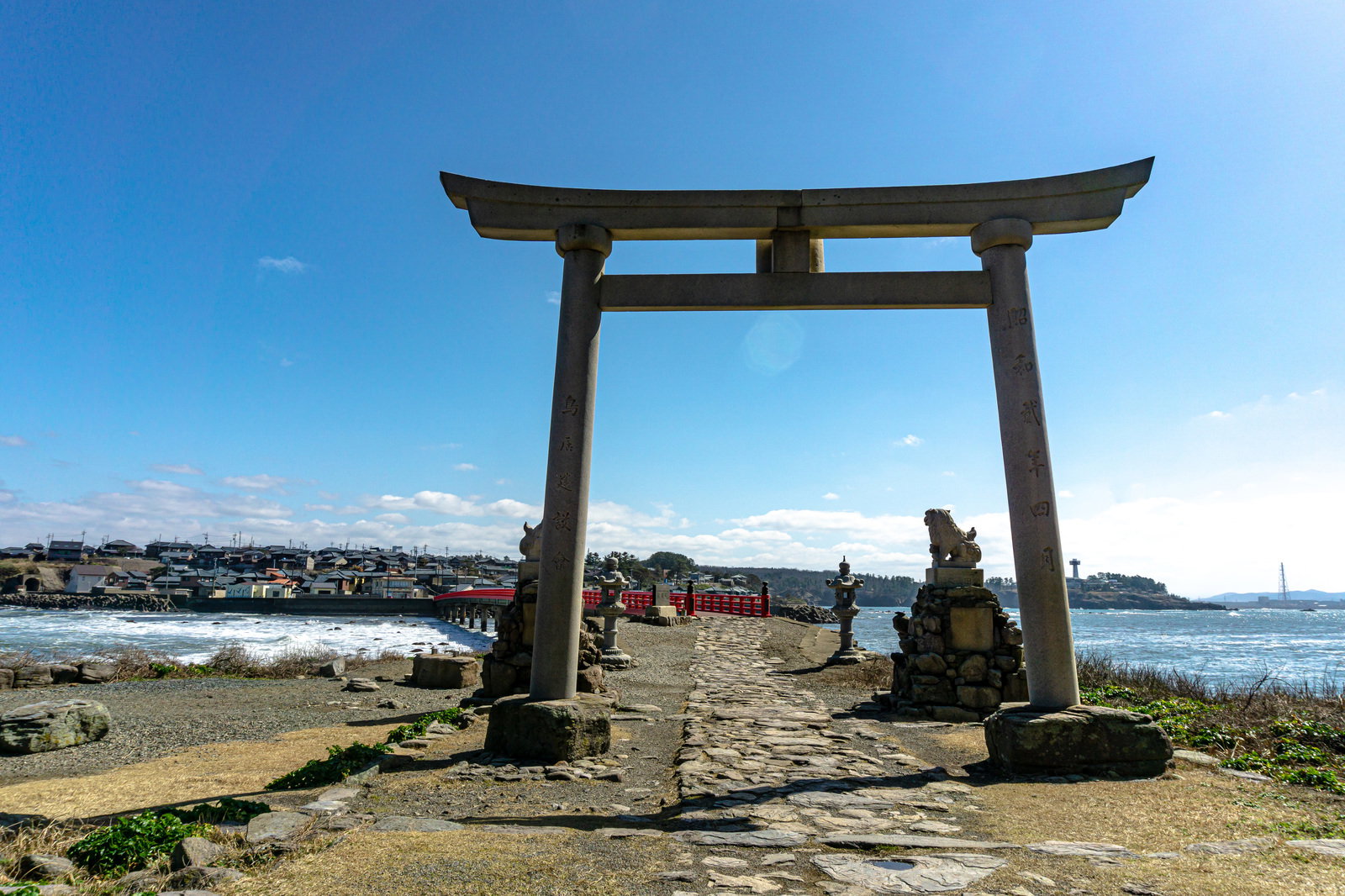 福井県雄島の石造りの鳥居越しに対岸の風景を望む