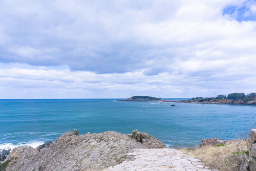 東尋坊の岩場へと続く石畳の先に見える雄島