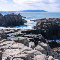 東尋坊から南西に見える臨海の工業地帯や霞む山の姿の写真