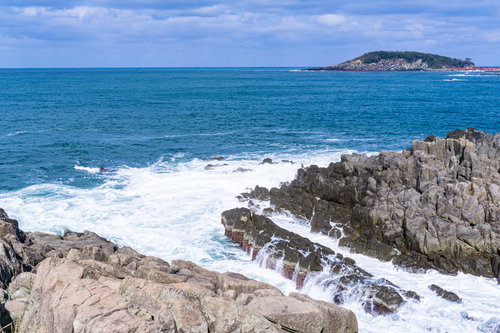 押し寄せる波が東尋坊の岩々にぶつかり白く泡立つ