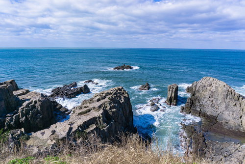 東尋坊の岩々に打ち寄せ飛び散る波しぶき