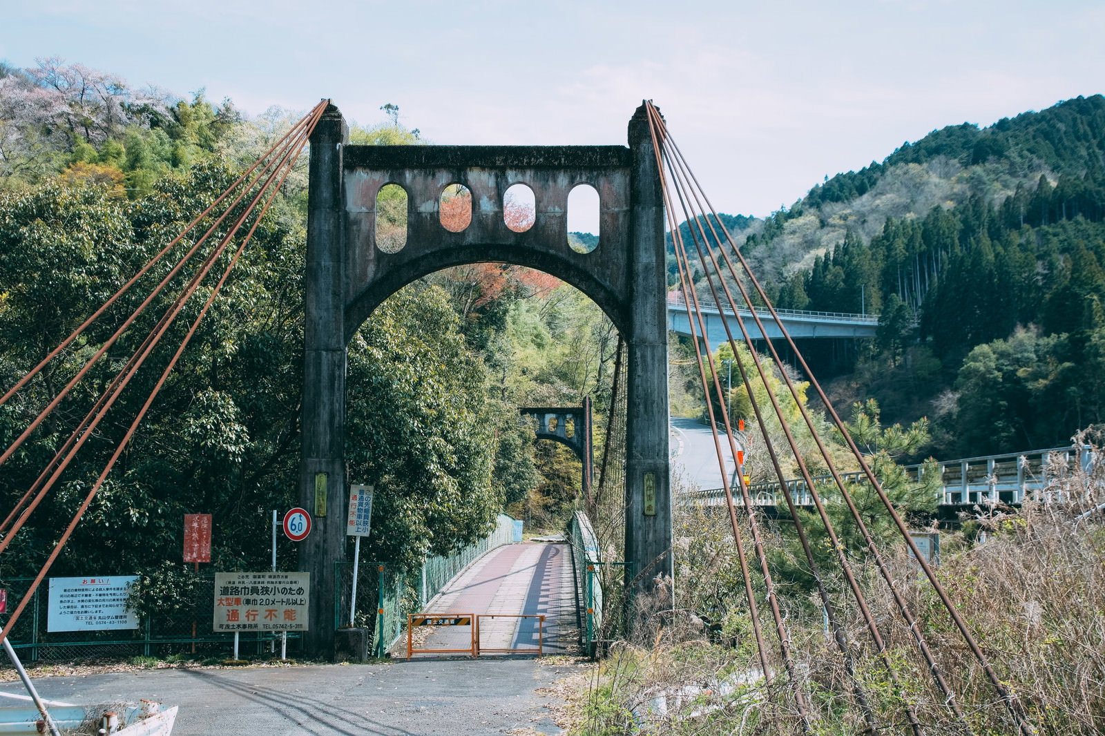 緑豊かな山間部に架かる小和沢橋とオレンジ色のバリケード