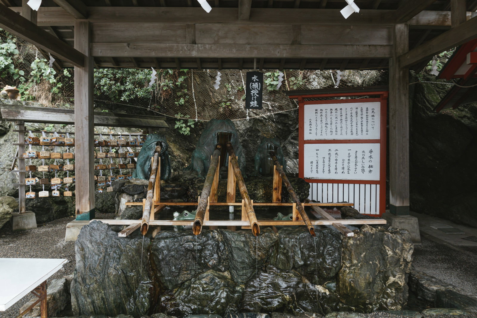 三重県二見興玉神社の石造りの手水舎に複数のカエルの石像が配置された御手水場