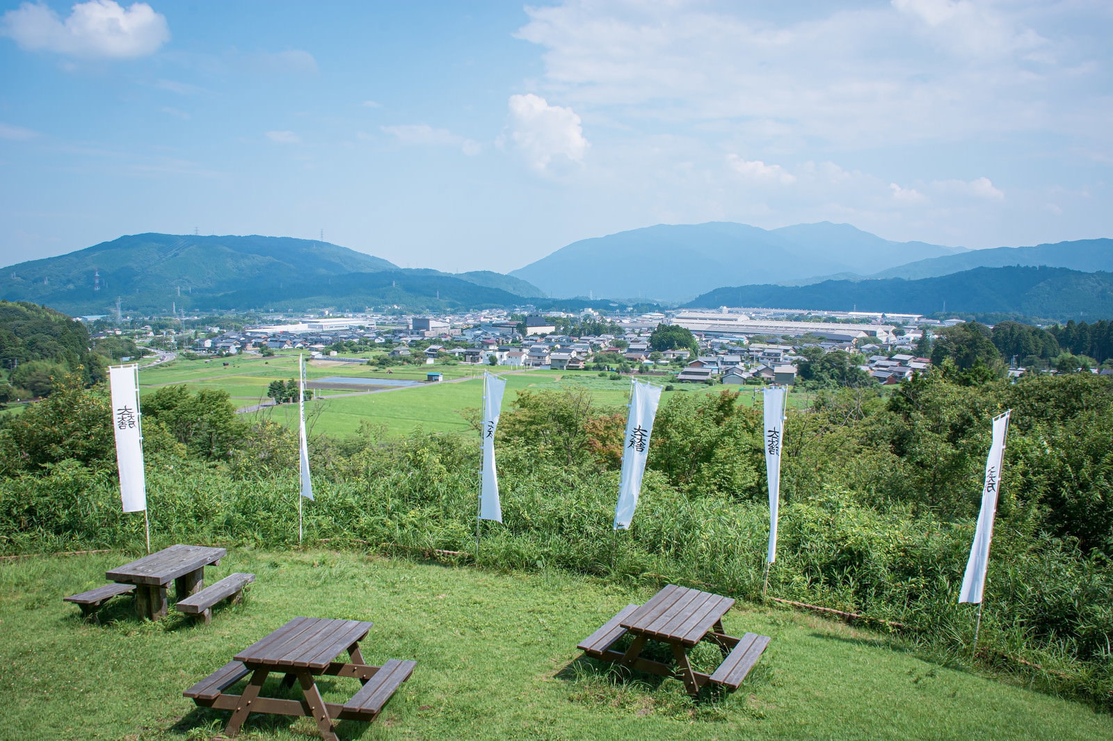 笹尾山展望デッキの木製テーブルとベンチ、背景に関ケ原の街並み