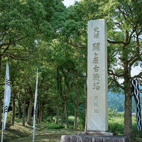 緑豊かな木々を背景に建つ開戦地の石碑の写真