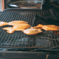 鋳物の焼き型から網の上に出された一丁焼きの天然ものたい焼きの写真