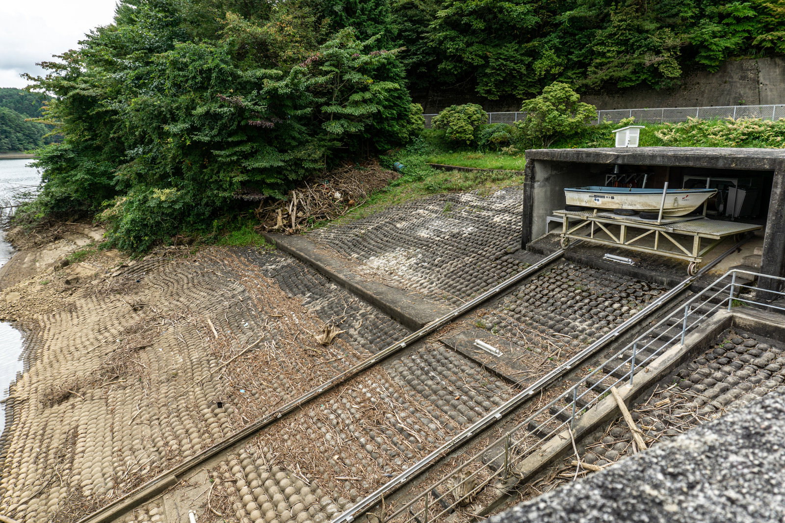 黒田ダムの湖畔に設置されたボート格納施設と湖面に続くレール