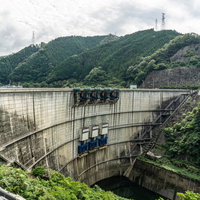 愛知県豊田市（左岸・画面奥）と岐阜県恵那市（右岸・画面手前）にまたがる巨大なアーチ式コンクリート型式の矢作)ダムの写真