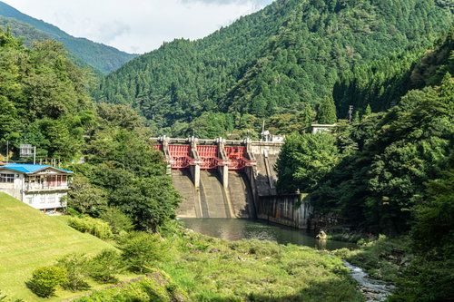 周囲の山の緑に囲まれた中で赤いゲートが一際美しく目立つ矢作第二ダム