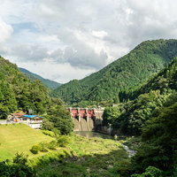 周囲の山の緑に囲まれた矢作第二ダムの写真