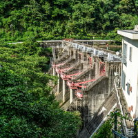 左岸の木の間から覗き見た矢作第二ダムのゲート付近の写真