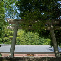 九頭竜湖畔沿いの道から見上げる九頭竜ダム建設に伴い水没した集落の神社を合祀した穴馬神社の鳥居と奥に見える拝殿の写真