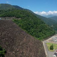 下に見える建物から巨大さが窺える右岸から眺めた九頭竜ダム堤体の写真