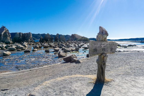 青空の下に点在する橋杭岩の奇岩群と穏やかな海面