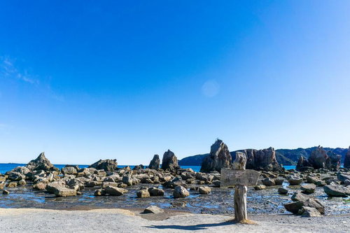 快晴の青空と強い太陽光が照らす橋杭岩の岩礁群とくしもと大橋