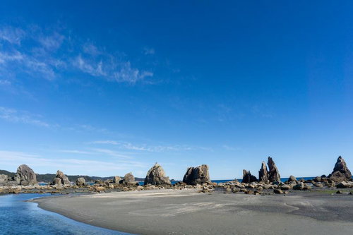 青い海と黒い岩礁群が作る複雑な海岸線