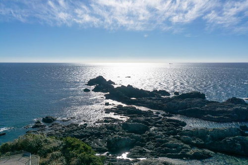 潮岬灯台から見える青い海と緑の崖に囲まれた海岸線と岩礁の空撮