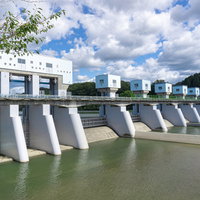 明治用水頭首工の手前右岸の土砂吐4門と左岸に向かって並ぶ洪水吐7門の写真