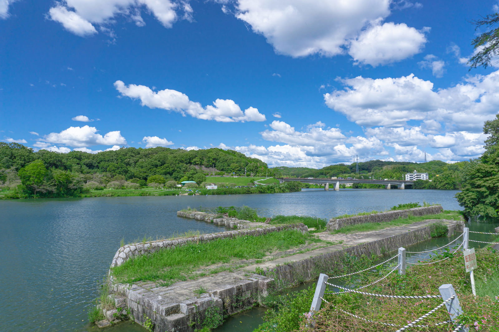Concrete structure of the former Meiji Yousui diversion dam remaining on the riverbank under the blue sky
