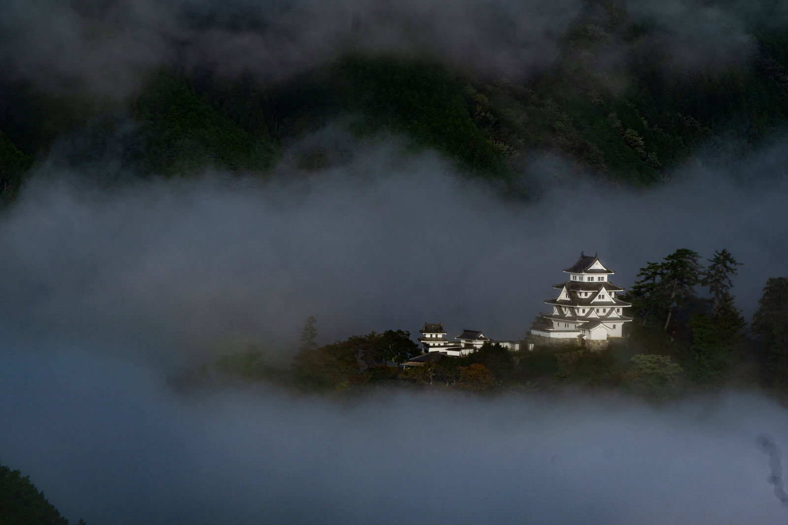 雲海に包まれた山間部から浮かび上がる郡上八幡城の天守