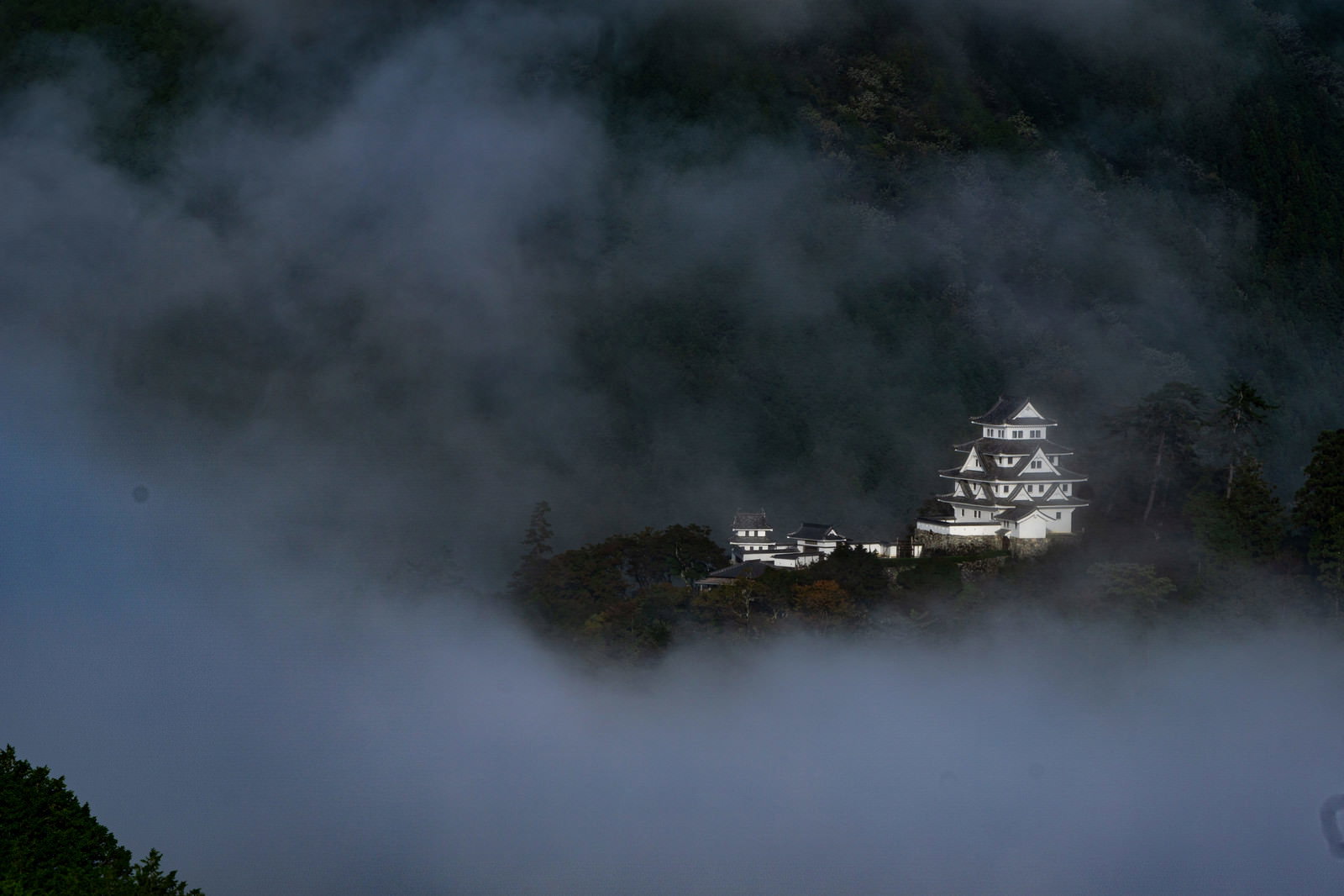 朝霧に包まれた山間に佇む郡上八幡城の風景