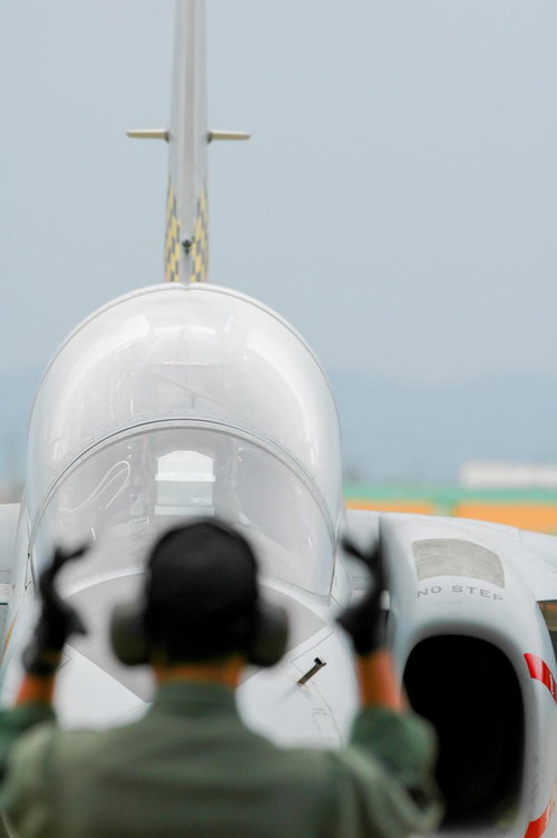 誘導するマーシャラーの後ろ姿越しのフライトを終えて戻ったT-4