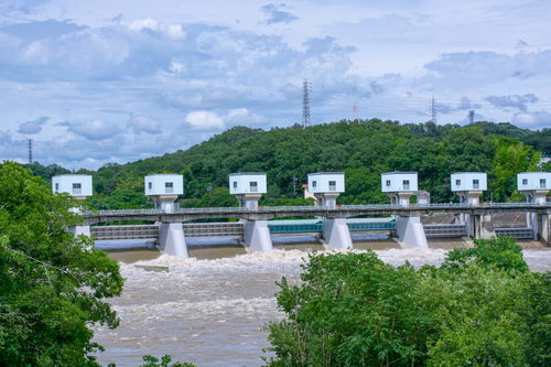 洪水吐から吐き出された濁流が茶色く波立つ雨あがりの明治用水頭首工