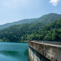 上流側からみたダム堤体の美しいアーチと何も突起物がないすっきりした天端の写真