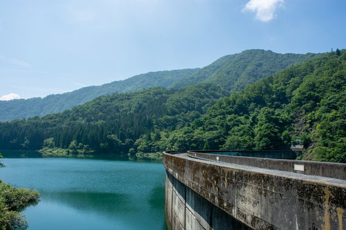 上流側からみたダム堤体の美しいアーチと何も突起物がないすっきりした天端