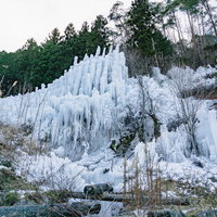 組み上げられた丸太に水をかけて作られた湧水公園の氷瀑の写真