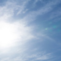 薄雲に隠された太陽と筋状の雲の写真