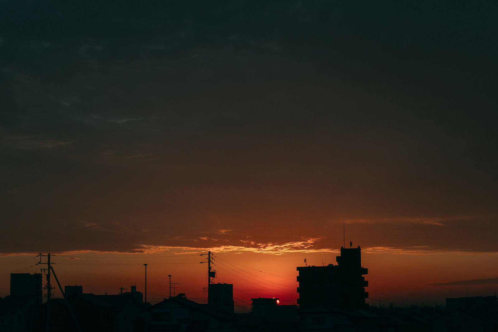 オレンジ色に染まった夕焼け空と街の建物のシルエット