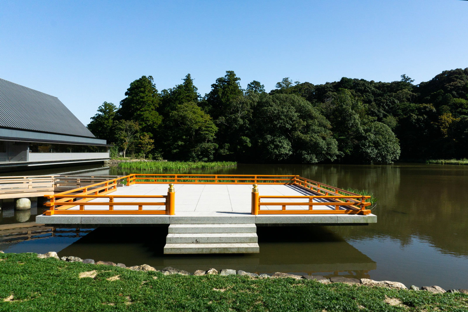 豊受大神社外宮の勾玉池に浮かぶ木製の奉納舞台と橋の風景