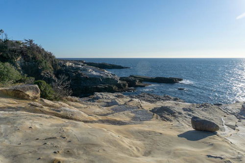 千畳敷の砂岩層と青い海が広がる岩場海岸の写真
