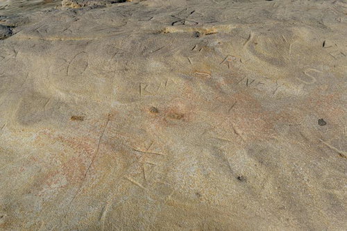 岩肌に刻まれた落書きと千畳敷の石肌の模様